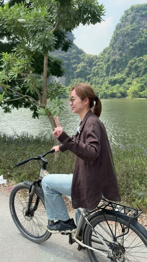 湖邊騎腳踏車，背後是綠色的山